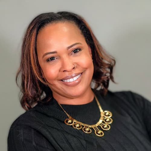 Portrait of a smiling woman with necklace, representing South Shore CDC.