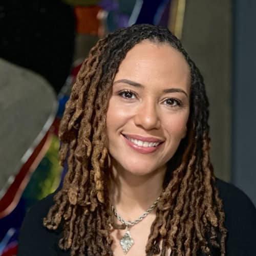 Portrait of a woman with dreadlocks smiling, representing South Shore CDC.